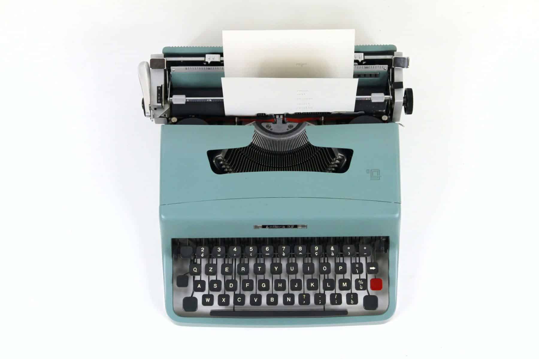 how to write a blog post fast. Photo of teal coloured typewriter.